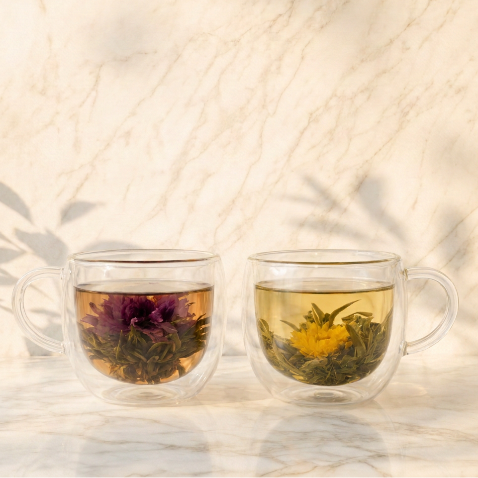 Tazas de vidrio con te floreciente abierto